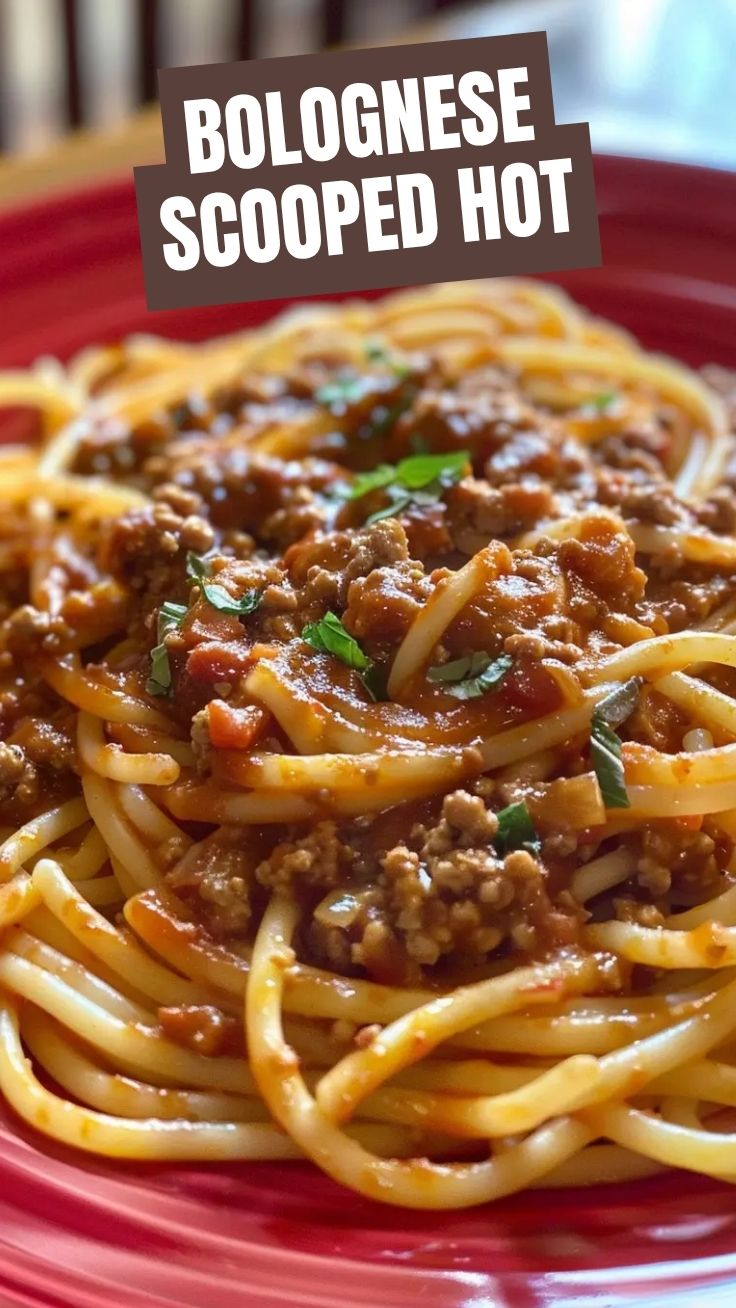 A steaming bowl of Spaghetti Bolognese garnished with fresh herbs.